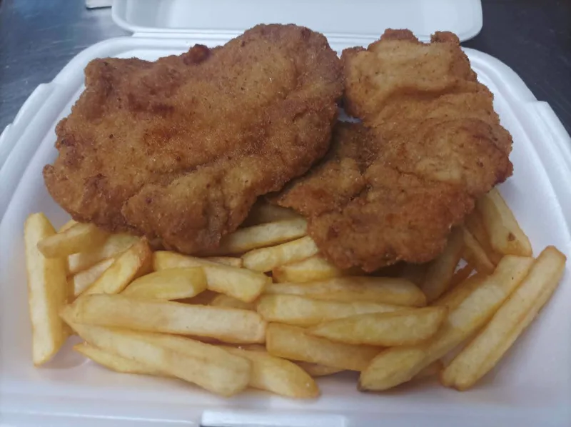 Gebackenes Schweineschnitzel mit Pommes oder Salat